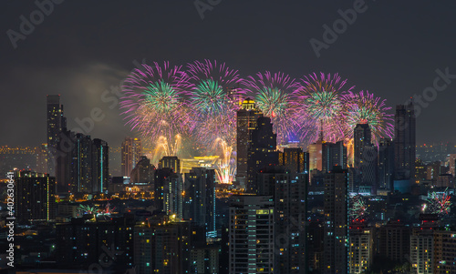 Colorful Firework with cityscape night light view of Bangkok skyline at twilight time. New Year celebration fireworks light up to sky at New Year festival with Copy space. No focus, specifically.