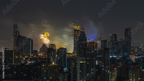 Colorful Firework with cityscape night light view of Bangkok skyline at twilight time. New Year celebration fireworks light up to sky at New Year festival with Copy space. No focus, specifically.