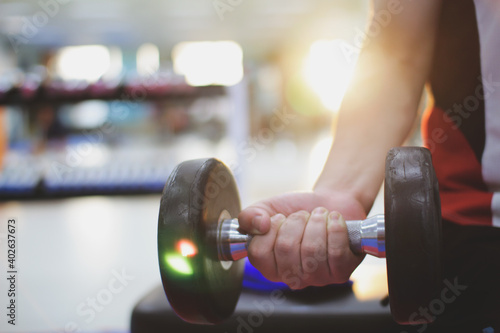  person exercising with dumbbells workout in gym,pumping up muscules with dumbbells photo