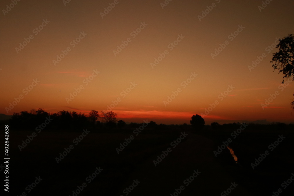 Orange light of sunrise, silhouette and blue sky in the morning Orange light of sunrise, silhouette and blue sky in the morning