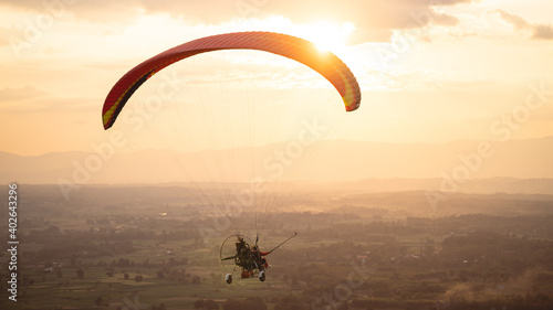 Silhouette picture of the Paramotor Flying through sunlight Sky Sunset,Freedom conept,copy space. Adventure conept.