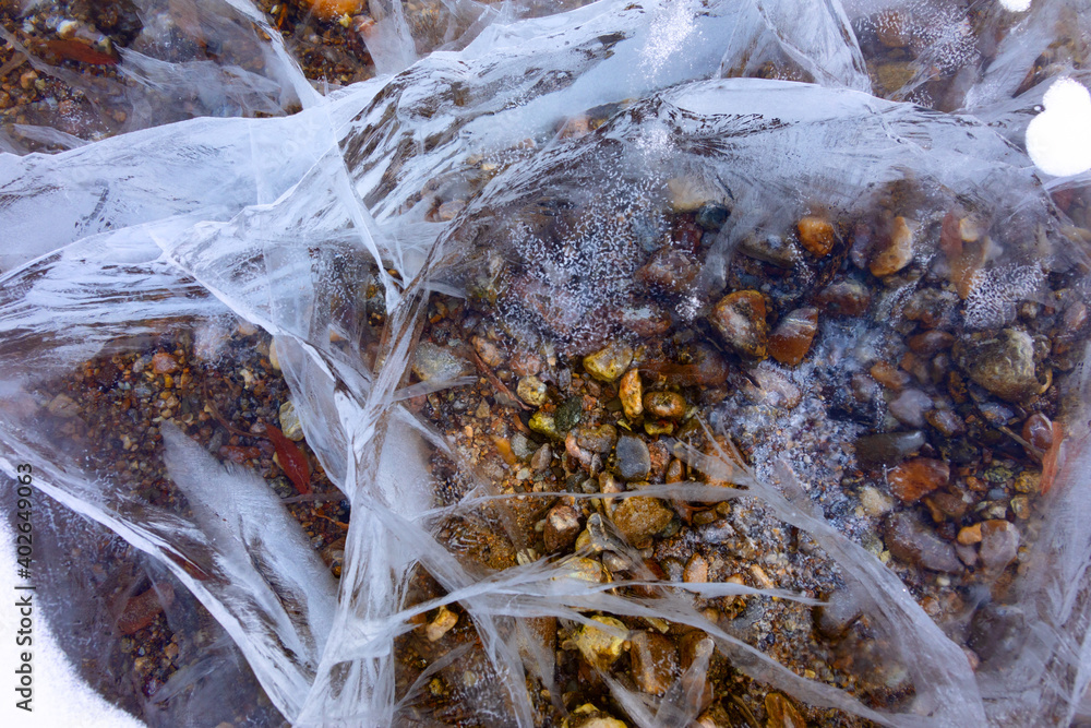 Close up shot of frozen waters with included of cracks, bubbles and herbs of baikal lake ice Close up shot of frozen waters with included of cracks, bubbles and herbs of baikal lake ice