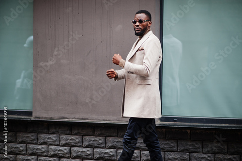 Stylish african american man wear beige jacket with sunglasses.