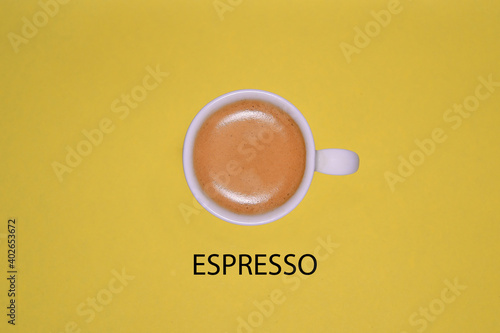 Cup of espresso on a yellow background.