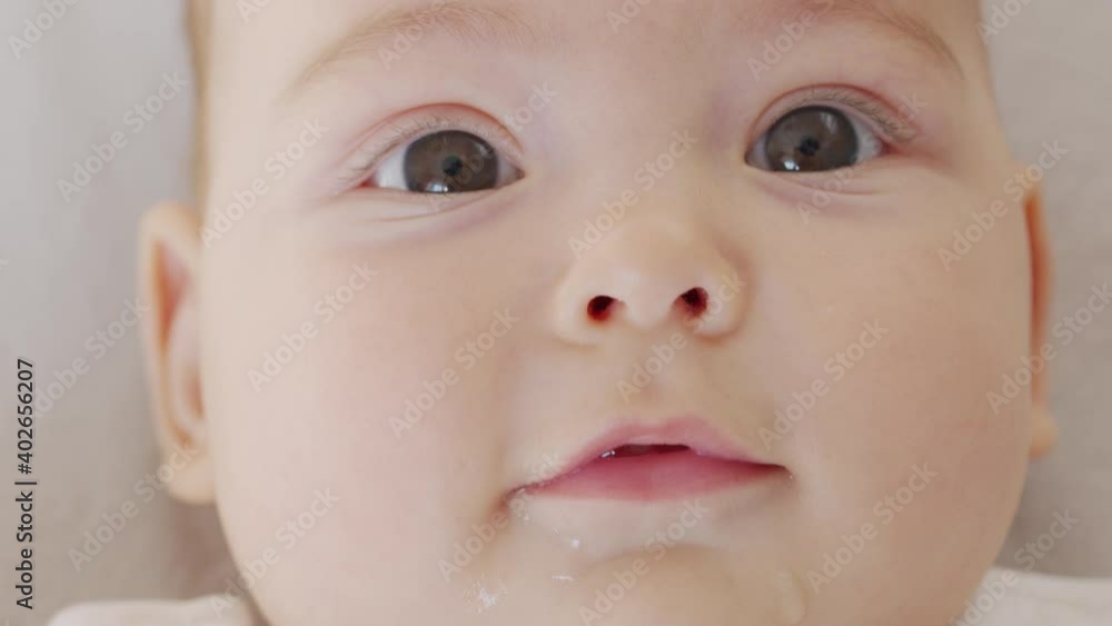 Beautiful Smiling Baby: A gorgeous little baby lies on the bed and smiles at the camera with a nice soft focus background. Beautiful Smiling Baby: A gorgeous little baby lies on the bed and smiles at the camera with a nice soft focus background.