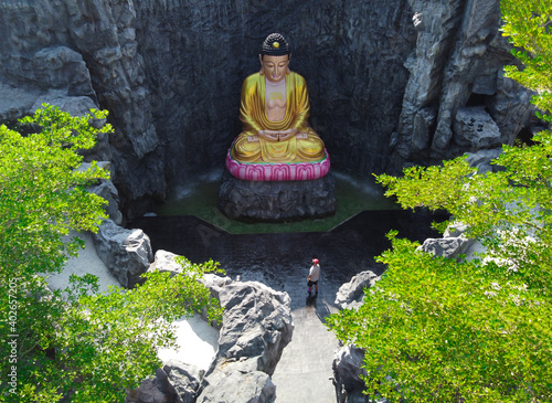 Tourist is sightseeing Big buddha statue in the cave at Wat Lak Si Rat Samoson, Samut Sakorn, Thailand. photo