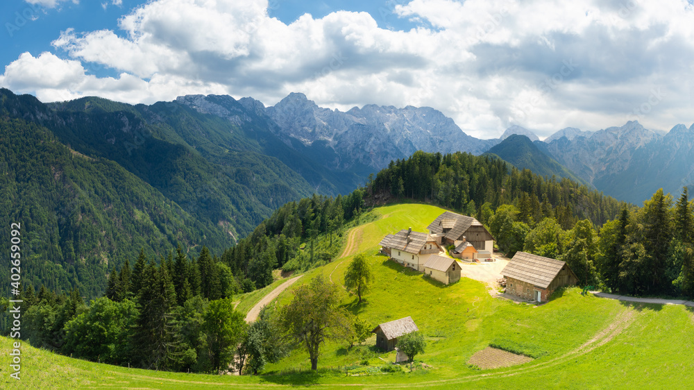 Amazing landscape with snowy mountains in Slovenia. Logarska Dolina and alpine rural farm with houses from the Solcava panoramic road, Logar valley, Slovenia, Europe.