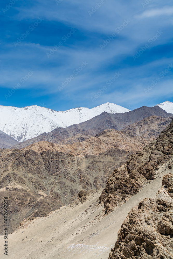Beautiful landscape of Himalayas barren mountains with white snow, and blue sky,  in Ladakh, Kashmir, view from Thiksey Monastery or Thiksey Gompa.