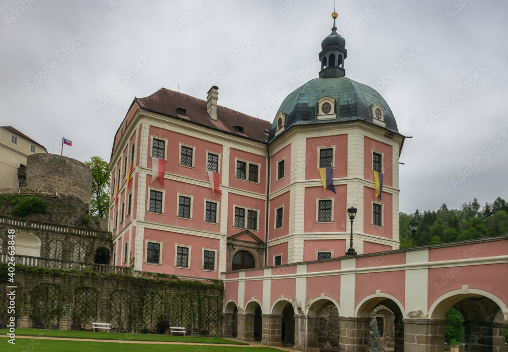 Baroque castle Becov nad Teplou (Czech Republic). an old building on a high rock on a summer day, an arched bridge. pink, white, gray cloudy sky. Popular with tourists from all over the world