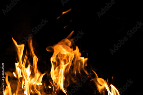 Fire flames on a black background. Abstract fiery texture. Realistic fire flames burn movement frame. Texture for Design. The texture of fire. Fire flames background. Blazing campfire. Sensitive focus © wattana