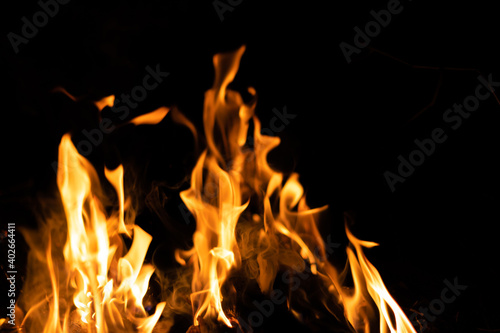 Fire flames on a black background. Abstract fiery texture. Realistic fire flames burn movement frame. Texture for Design. The texture of fire. Fire flames background. Blazing campfire. Sensitive focus