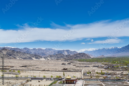 Beautiful landscape with fields, Tibetian buildings, snow mountains, and blue sky, in Ladakh, Kashmir, view from Thiksey Monastery or Thiksey Gompa