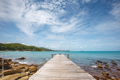 wide angle shot of dock to the sea with bright blue sky and cloud in relax summer day