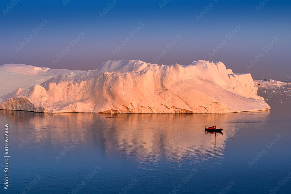 Greenland Ilulissat color glaciers at polar night with red sailing boat