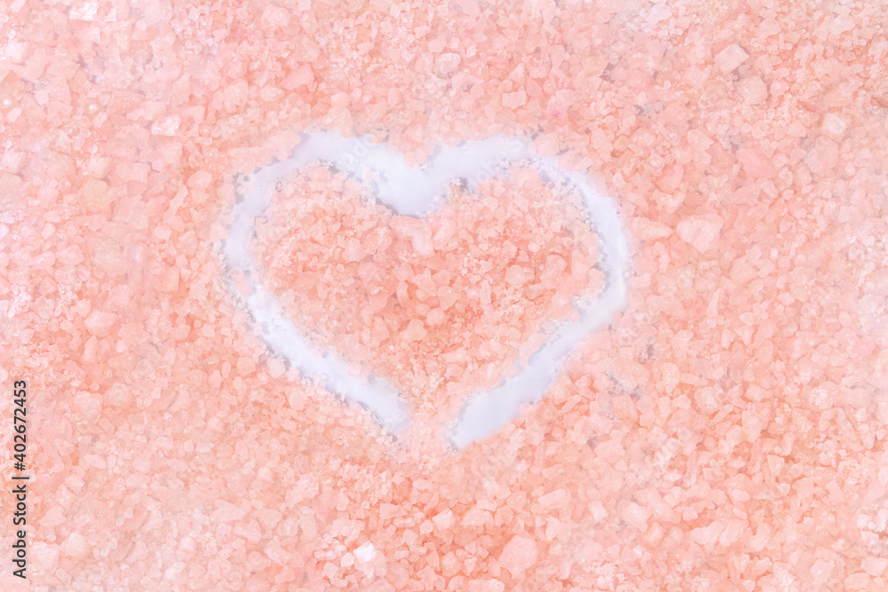 Beige pink background with white heart. Sea salt. Valentine's Day. Texture