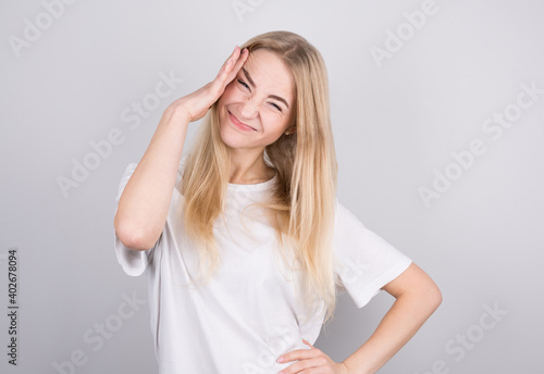 Young woman with a headache holds her temples with her hands. Health, migraine and headache concept.