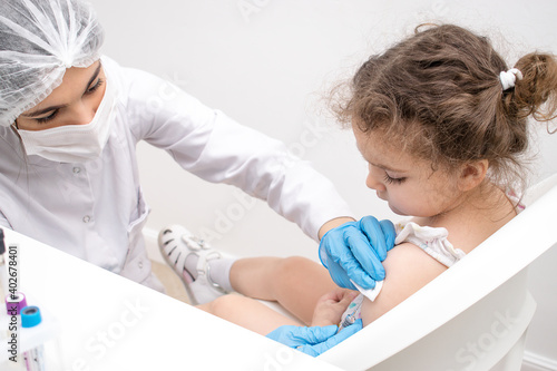 Fototapet Female doctor vaccinates a little girl in the arm