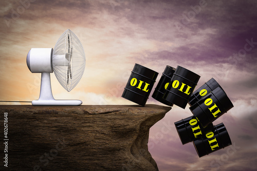 A fan blows many Black Metal Oil Barrels on cliff at sunset magenta day. Oil price falling or declining prices or crisis or decrease of petroleum costs or crude or recession concept. 3D illustration photo