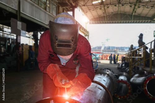 Welder mounts in the trunk pipeline electrochemical piping shop in shipyard by wearing protection mask