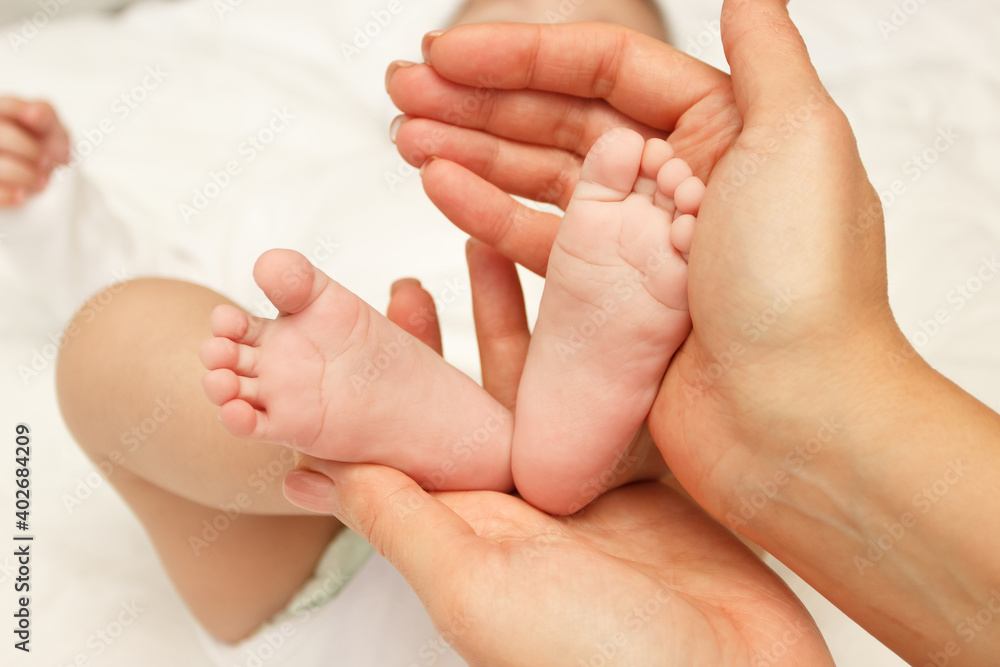 Hands of woman holds baby, blurred background Hands of woman holds baby, blurred background