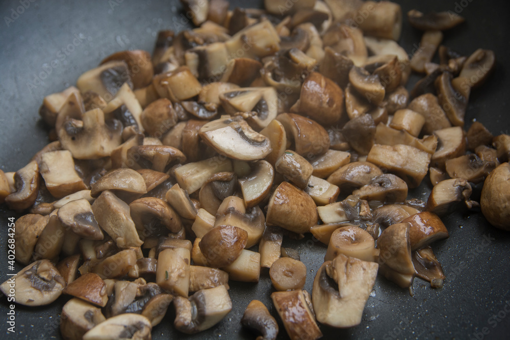 Close up view of sauteed slices of Common Mushrooms (Agaricus bisporus) cooking in the pan Close up view of sauteed slices of Common Mushrooms (Agaricus bisporus) cooking in the pan