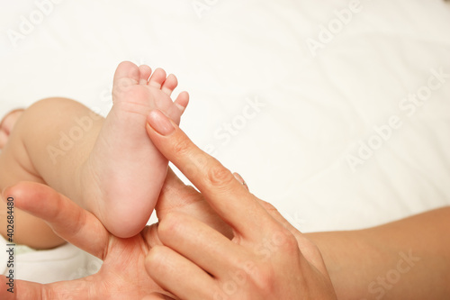 Hands of woman holds baby foot  blurred background