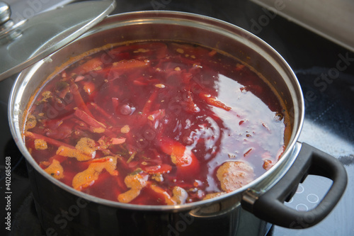A boiling pot of traditional sour Borscht soup, one of the most famous dishes of Ukrainian cuisine, made with beetroots as one of the main ingredients, which give the dish its distinctive red color