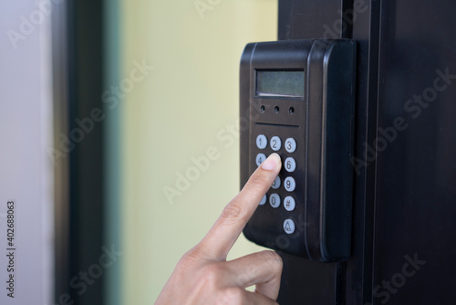 Businesswoman press number buttons for password and match fingerprint to access an office building.