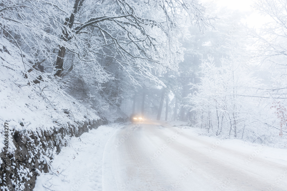 A road in the winter forest. Beautiful winter landscape with coniferous forest and mountain serpentine. Snow-covered winter fairy tale. Empty road tall spruce trees. The concept of travel in winter. A road in the winter forest. Beautiful winter landscape with coniferous forest and mountain serpentine. Snow-covered winter fairy tale. Empty road tall spruce trees. The concept of travel in winter.