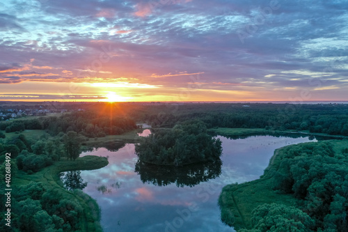 Panoramic aerial view of a beautiful sunset and the reflection of the sky in the summer water, colorful clouds