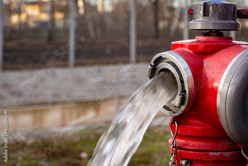 Close up of Water flowing from in open red fire hydrant photo