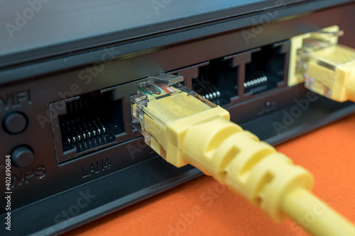 patch cords are yellow inserted into the ports of the router to access the Internet. router on a blue background