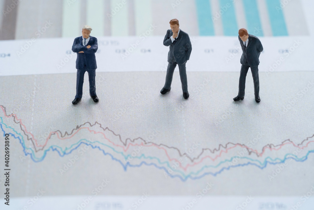 Analysis stock market investment concept , three businessman miniature figure standing and analysts stock technical chart. Analysis stock market investment concept , three businessman miniature figure standing and analysts stock technical chart.