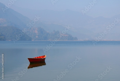 Boat on the lake, a fishing boat in calm lake water, an old wooden fishing boat, a wooden fishing boat in still lake water.  photo