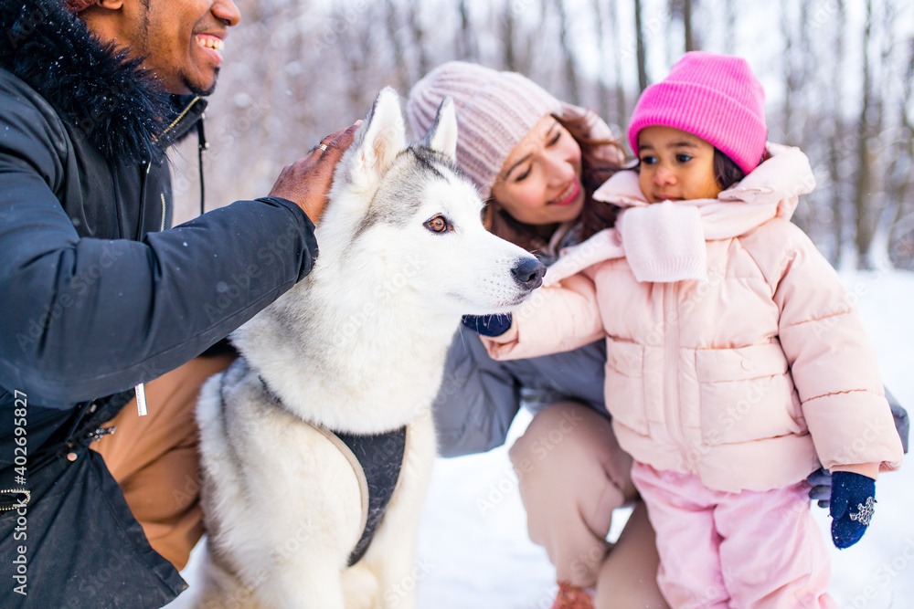 mixed race family in threesome spending new year holidays in park with their husky dog mixed race family in threesome spending new year holidays in park with their husky dog