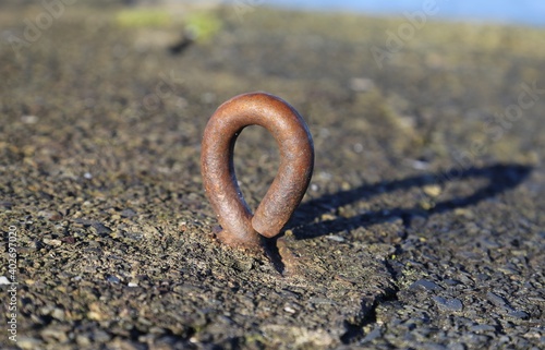 A close up view of a metal mooring eye bolt in the harbour wall at New Quay, Ceredigion, Wales.
