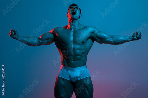 Muscular man showing muscles. Strong male naked torso abs
