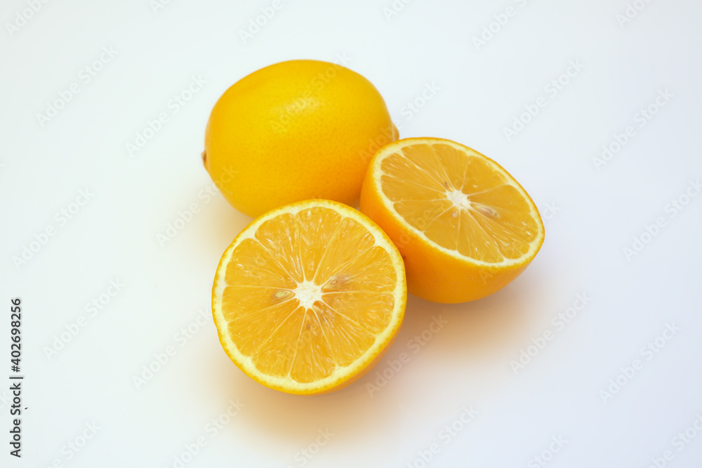 whole and split lemons on a white whole and split lemons on a white