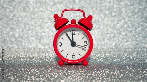 The red evening clock shows five minutes to midnight on a silver glitter background.