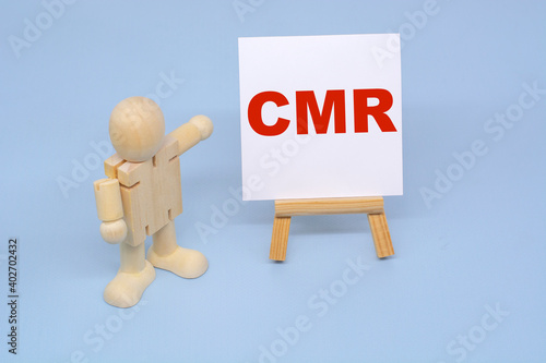 A wooden figure of a man points to the inscription CMR. Business Concepts photo