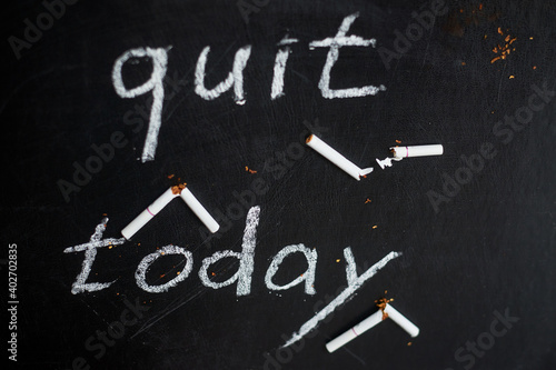 Stop smoking today concept. Broken cigarettes and inscription- quit today.