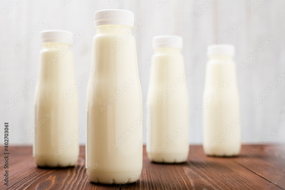 Bottles with milk, yogurt on a light background. Natural dairy products. Bottles with milk, yogurt on a light background. Natural dairy products.