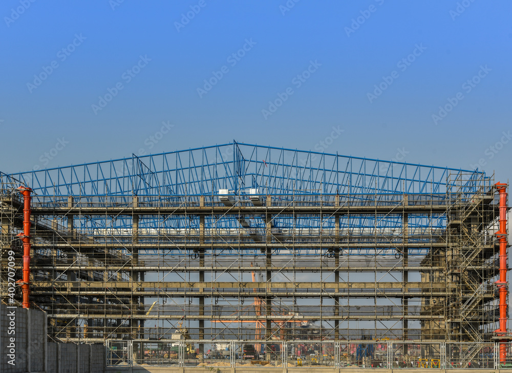 Steel structure factory in construction site on blue sky background.