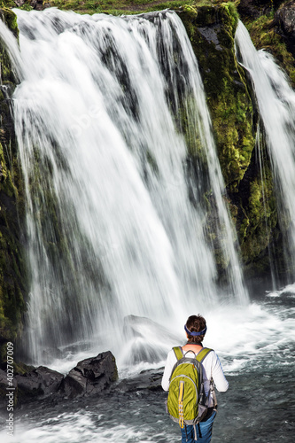 Elderly woman admiring the powerful waterfall