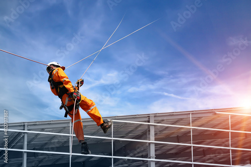 Fototapeta Safety sprinkling worker on high wear dresses and safety man with harness concept on steel structures success from work in site construction on blue sky background