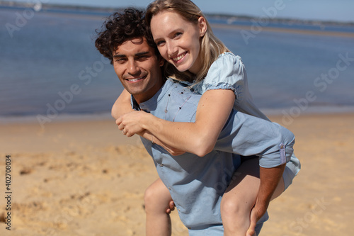 couple at beach woman hugging the man from behind