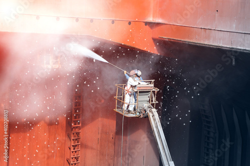 High pressure water jet to cleaning with Old ship washing  on Trucks have sherry piker, worker wear equipment protective safety harness and PPE in cargo hold of cargoship.