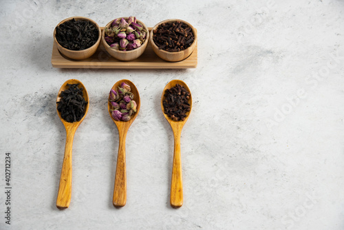 Wooden spoons with dried roses, loose teas and cloves
