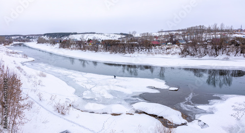 The spring river in the village began to thaw from the ice.The ice in the river began to melt. © Dmitrii Potashkin