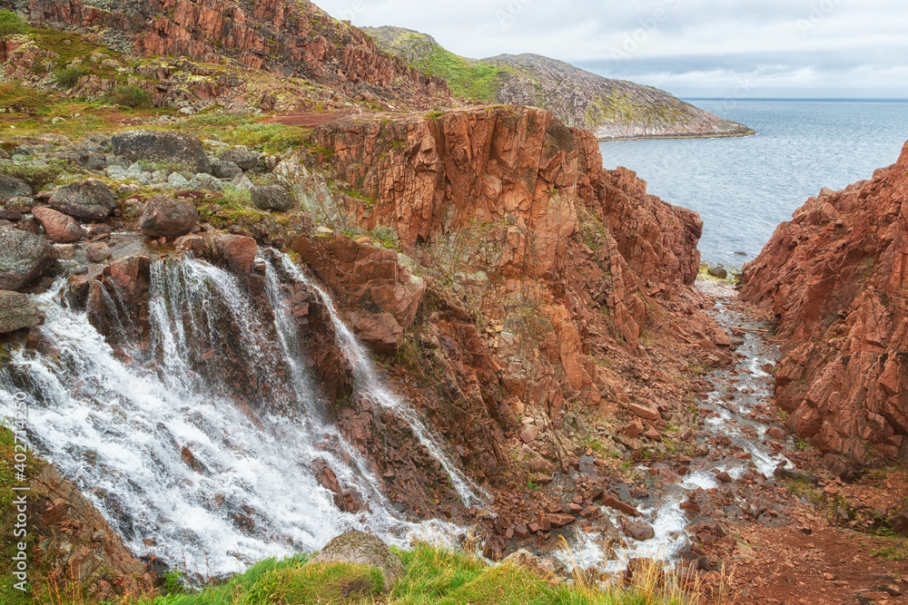 Rocks, a waterfall and the Barents Sea near the village of Teriberka